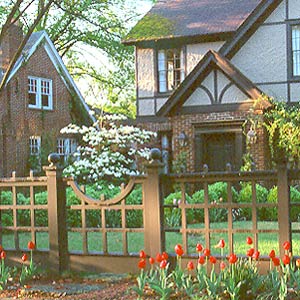 Tudor style home with matching fence and gate.