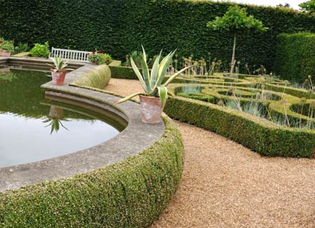 The Mediterranean garden at Houghton Hall. Note the 'bullnose' boxwood border around the raised pool. Brilliant! Love the potted agaves too.