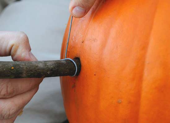 JackOLantern03 To come up with the wire length I measured how far down I wanted the pumpkins to hang & doubled it. Then I tacked on a few inches for tying to the dowels.