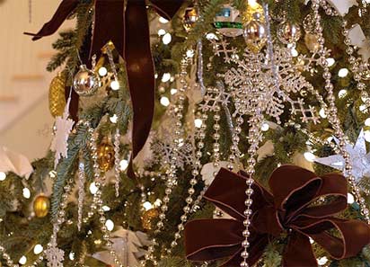 Xmas2011_01 Huge brown velveteen ribbons, silver starburst and beads, glittery snowflakes, golden glass pinecones and homemade white salt dough ornaments lend a rustic feel.